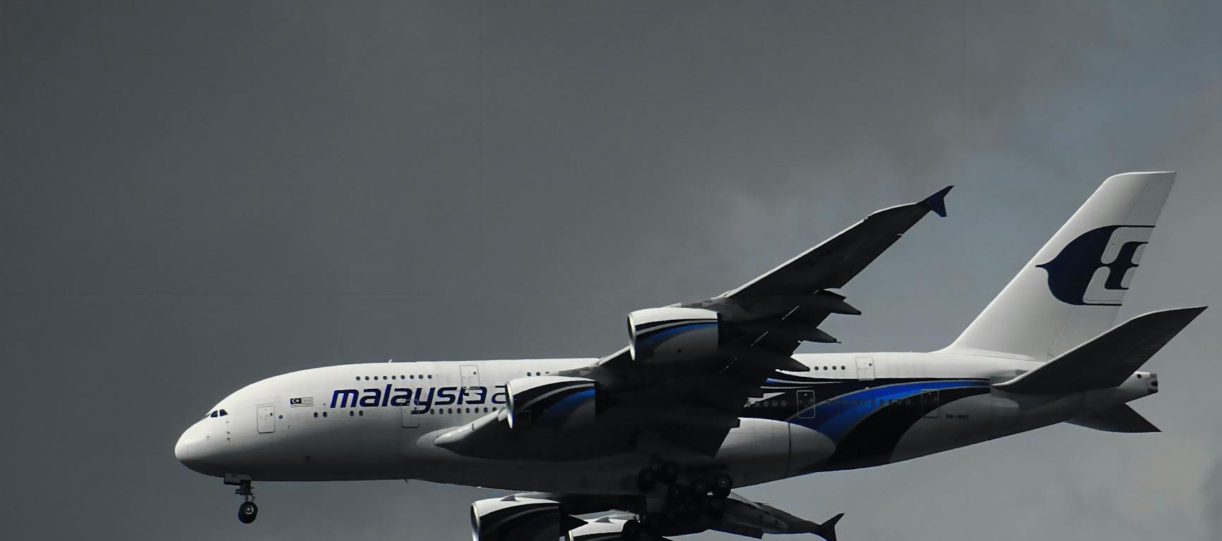 white malaysian airlines under white clouds
